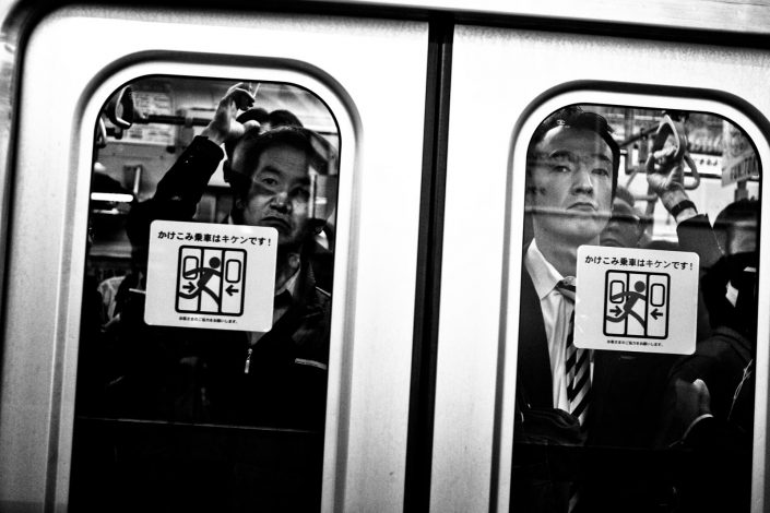 Japanese salarymen in front of metro door. Looking angry at me. Street Photography by Victor Borst