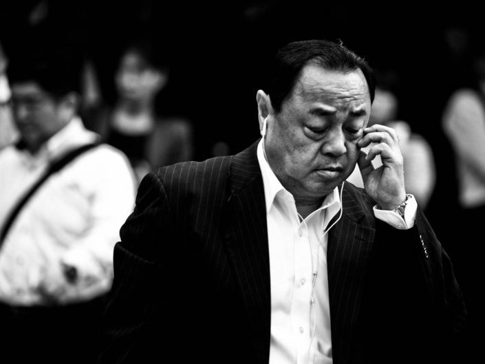 Portrait of Japanese man scratching near his eye. Street Photography by Victor Borst