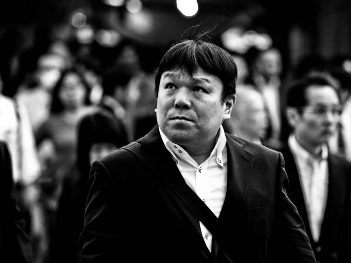 Portrait of a salaryman at Shimbashi station. he is looking up. Street Photography by Victor Borst